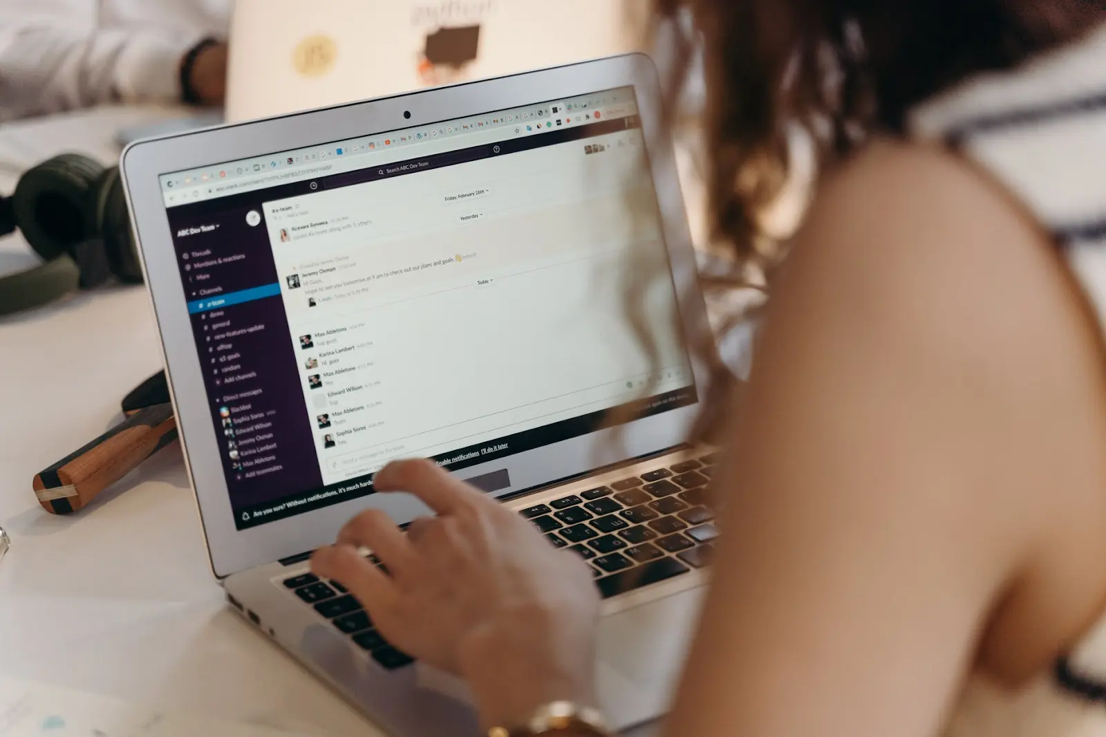 A person using Slack on a laptop to communicate with their team